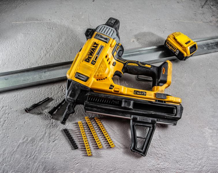 Clavadora a batería DEWALT DCN890P2 con accesorios y fijaciones sobre superficie de concreto.